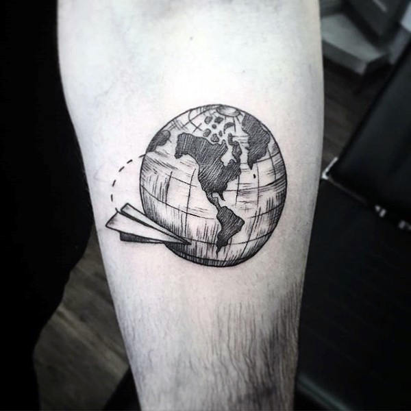 Black shaded globe and paper airplane tattoo on inner arm