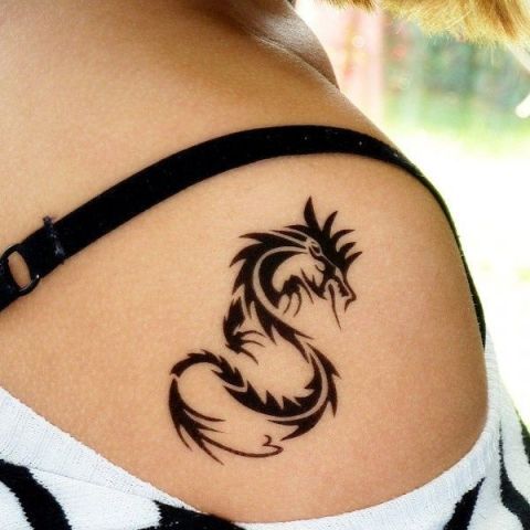 Black small tribal dragon tattoo on right shoulder for women