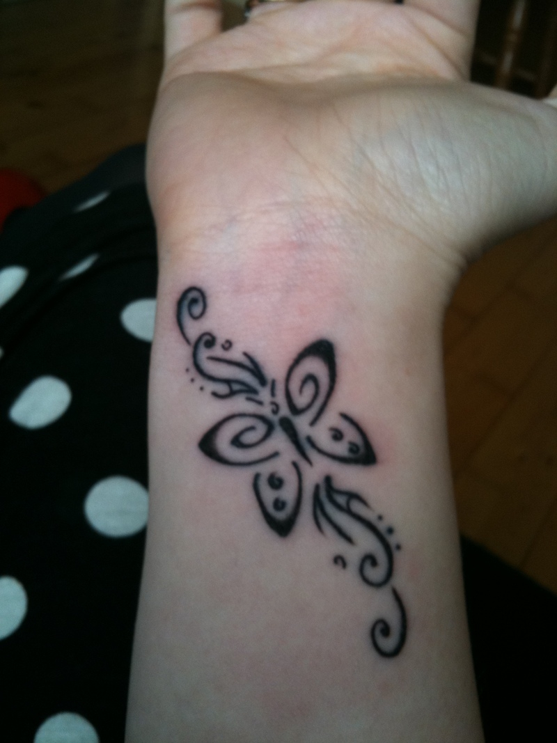 Black tribal butterfly tattoo design on inner wrist