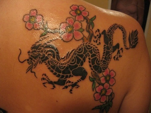 Black tribal dragon and coloured flower tattoo on right upper back