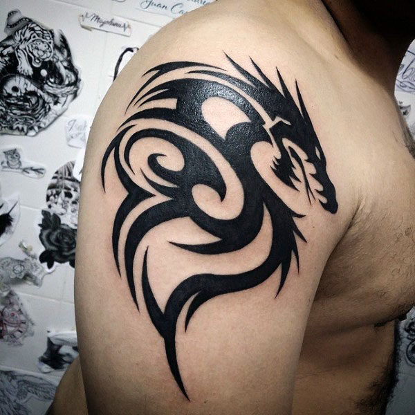 Black tribal dragon tattoo on right upper arm
