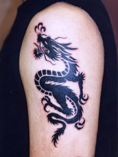 Black tribal dragon tattoo on left upper arm
