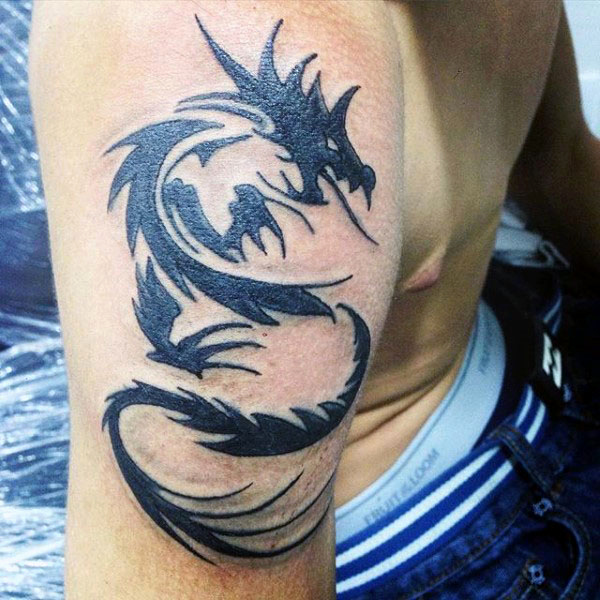 Black tribal dragon tattoo on male right bicep