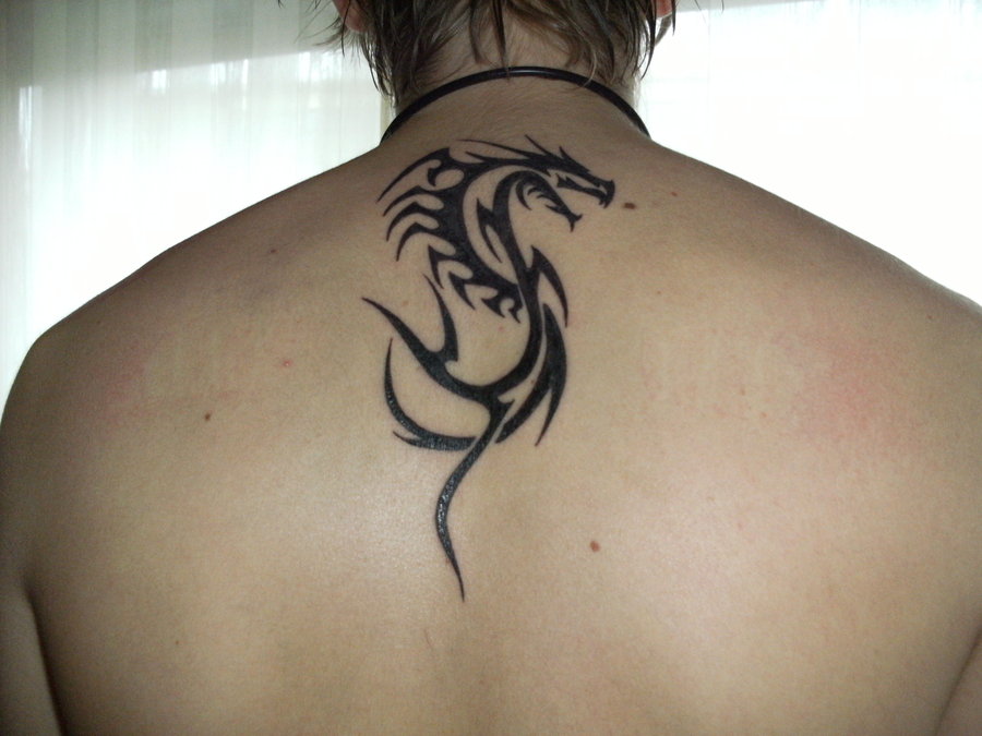 Black tribal dragon tattoo on upper middle back by Darghon