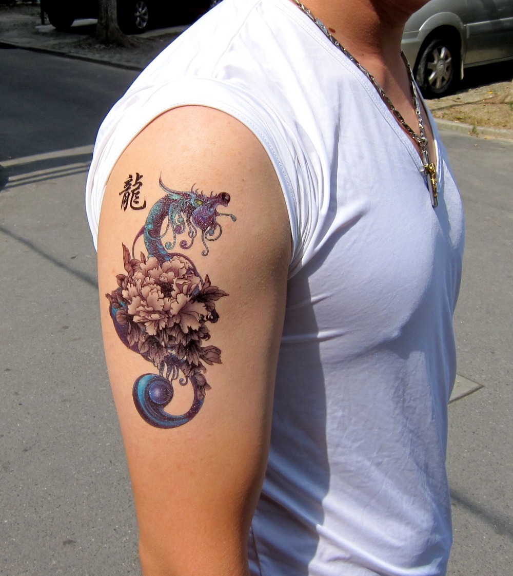 Blue and black dragon flower tattoo on right upper arm for men