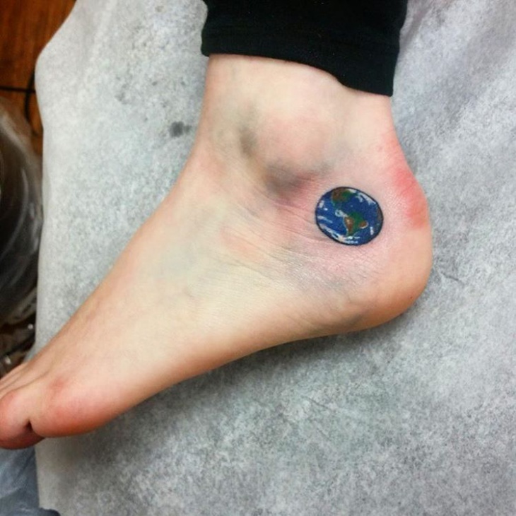 Blue and green 3d earth tattoo on left foot