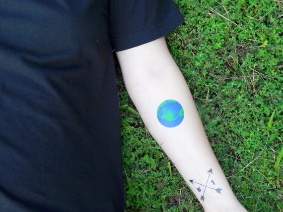 Blue and green 3d earth tattoo on lower inner arm