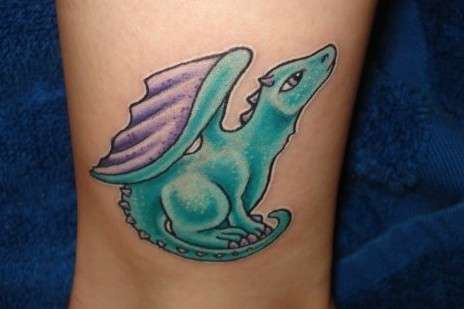Blue and purple baby dragon tattoo on inner arm