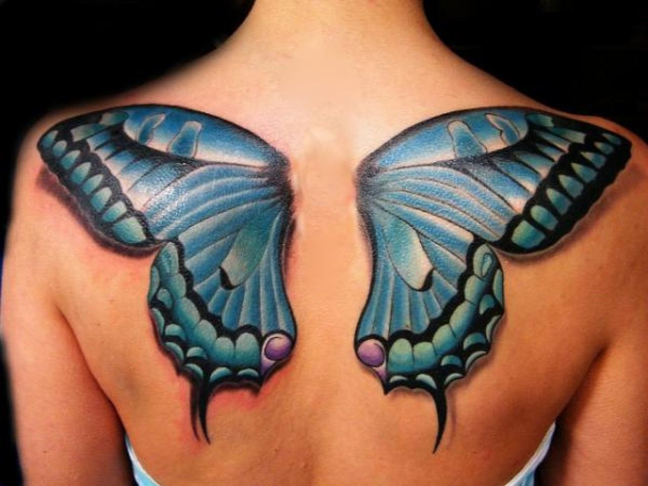 Blue butterfly wings tattoo on upper back