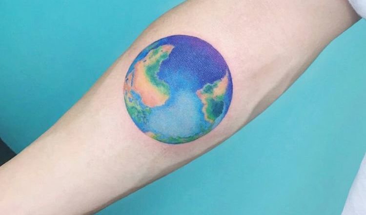 Colored 3d earth tattoo on mid inner arm