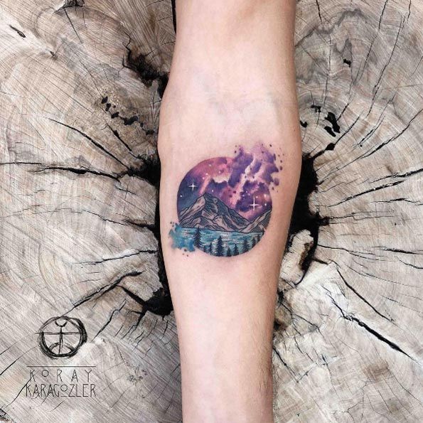 Colored earth with scenery tattoo on inner arm