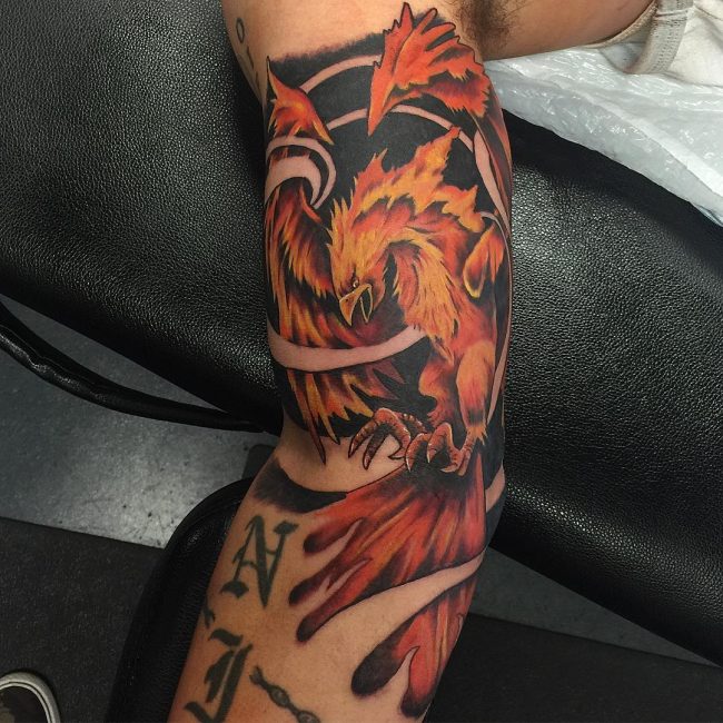 Colorful Phoenix On Flames Tattoo On Sleeve
