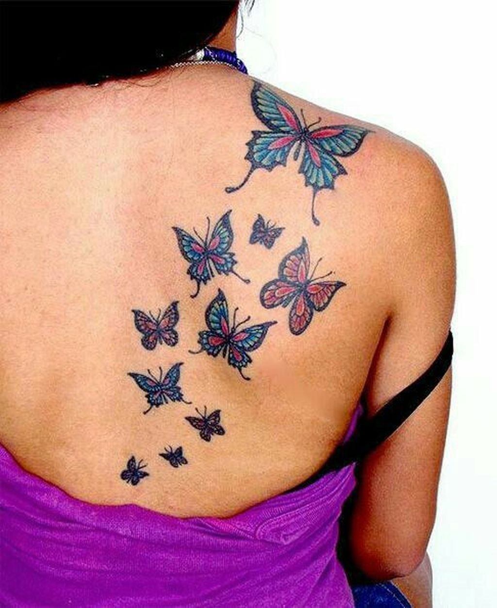 Colorful butterflies on girl’s back tattoo