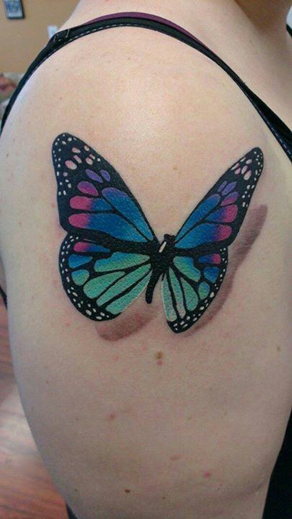 Colorful butterfly tattoo on girl’s upper arm