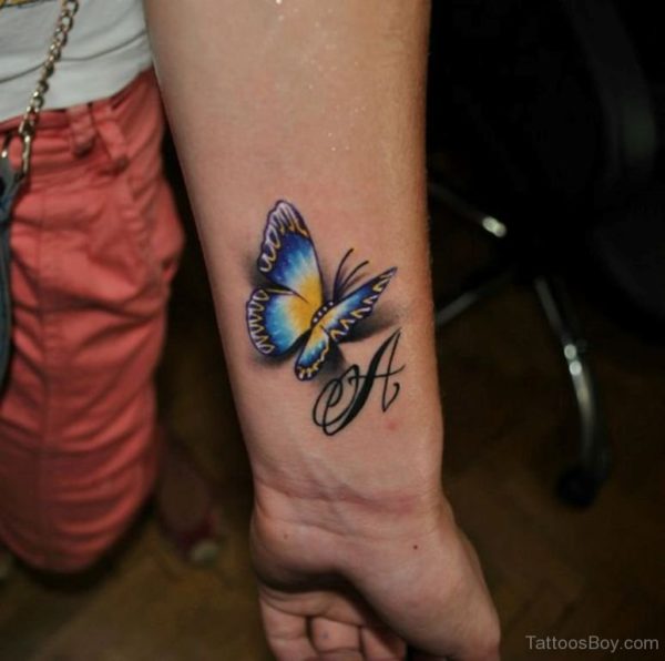 Colorful realistic butterfly tattoo with letter on wrist