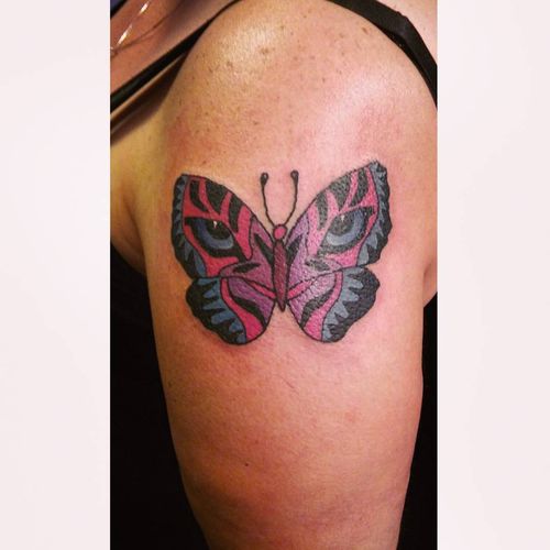 Colorful tiger eyes butterfly tattoo design on biceps