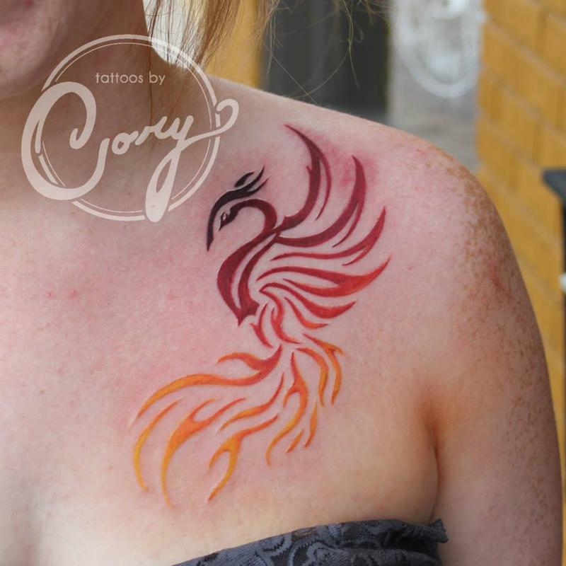 Colorful tribal phoenix tattoo on girl front shoulder by Cory Claussen