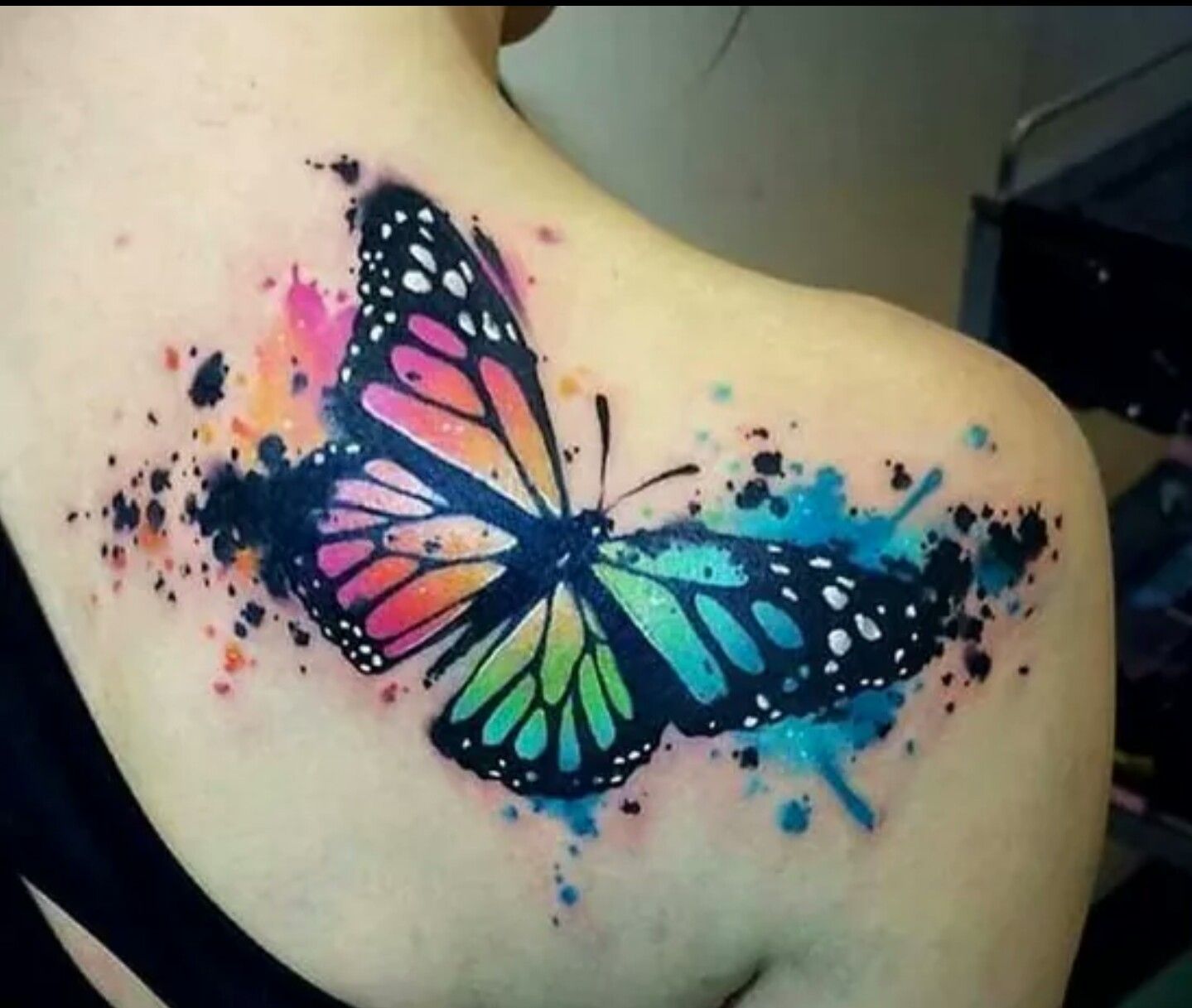 Colorful water color butterfly tattoo on right back shoulder