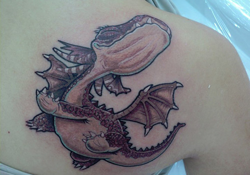 Colored baby dragon tattoo on upper right back shoulder