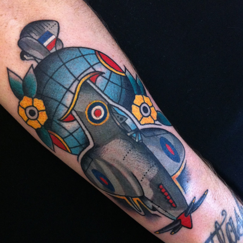 Colored globe and airplane tattoo on half sleeve