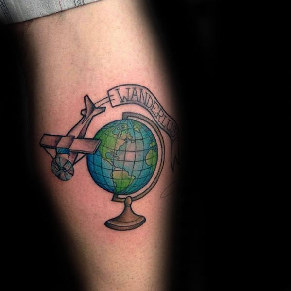 Colored globe and airplane tattoo with wanderlust banner on calf