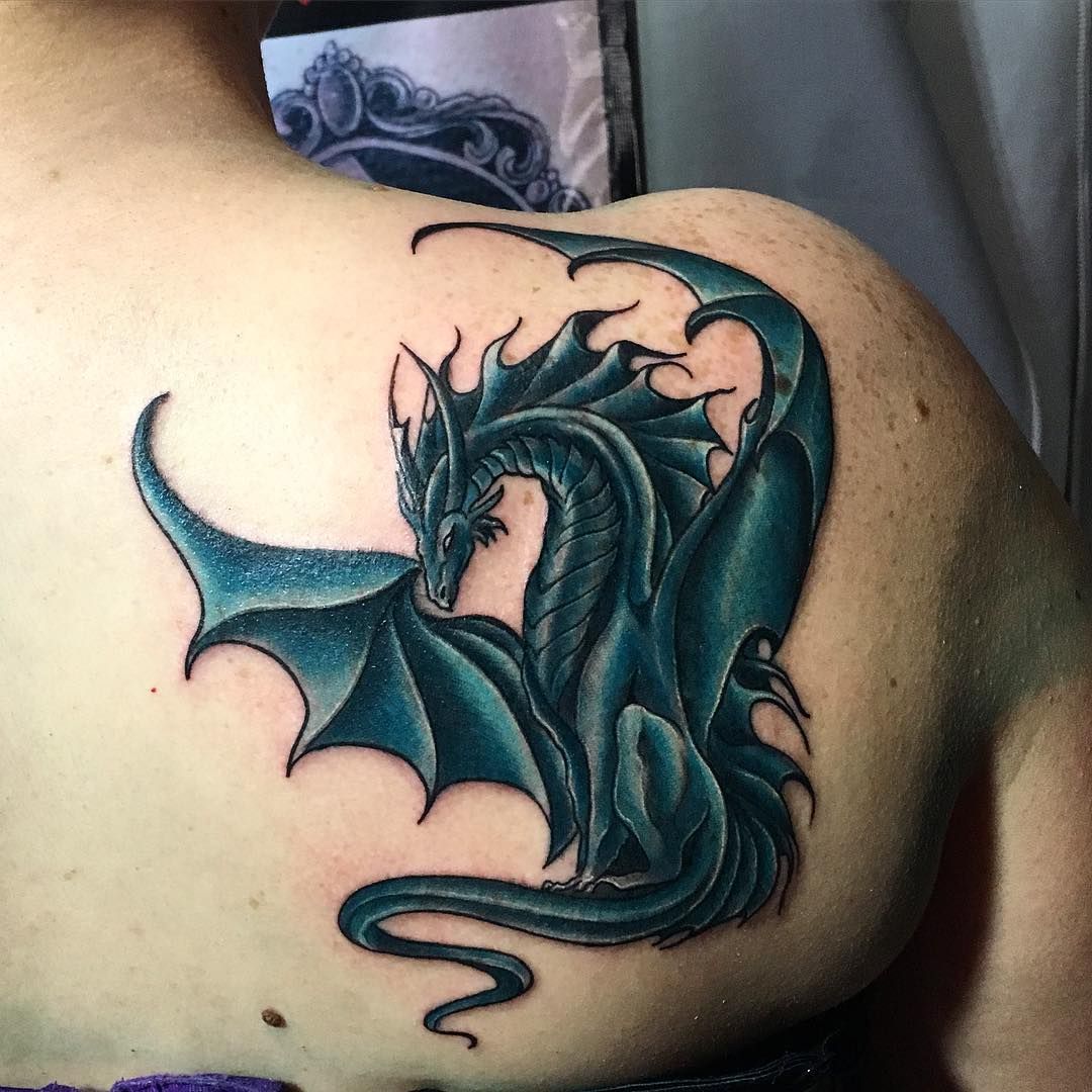 Dark Green dragon tattoo on woman’s upper right back shoulder