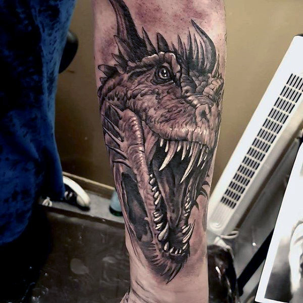 Fierce face dragon tattoo on leg