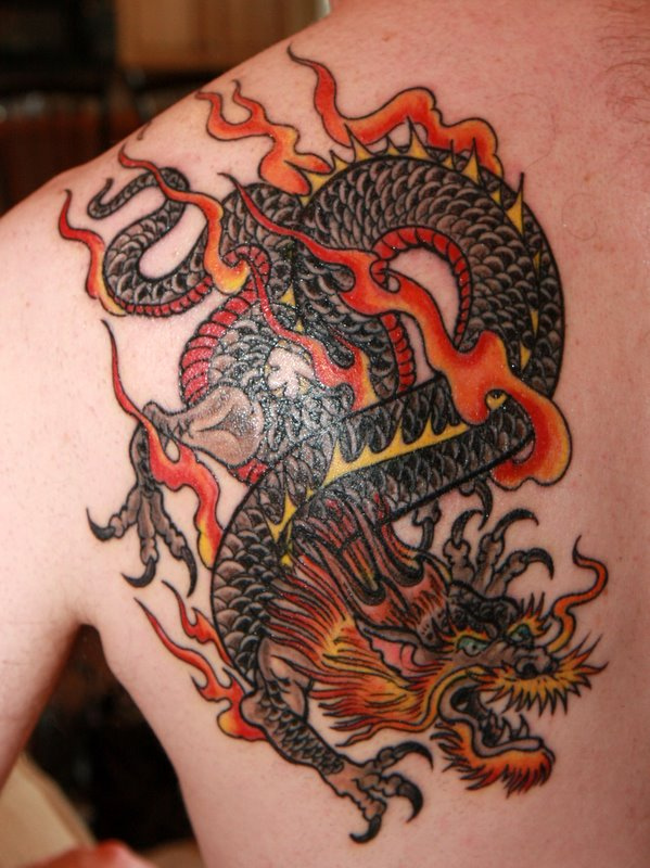 Flaming dragon tattoo on left upper back