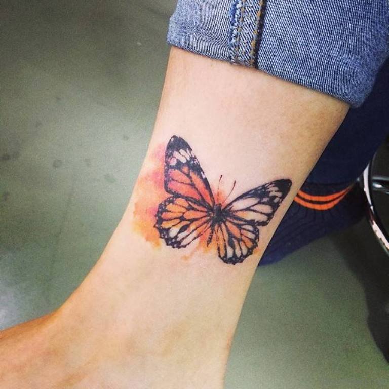 Orange and black butterfly tattoo on ankle