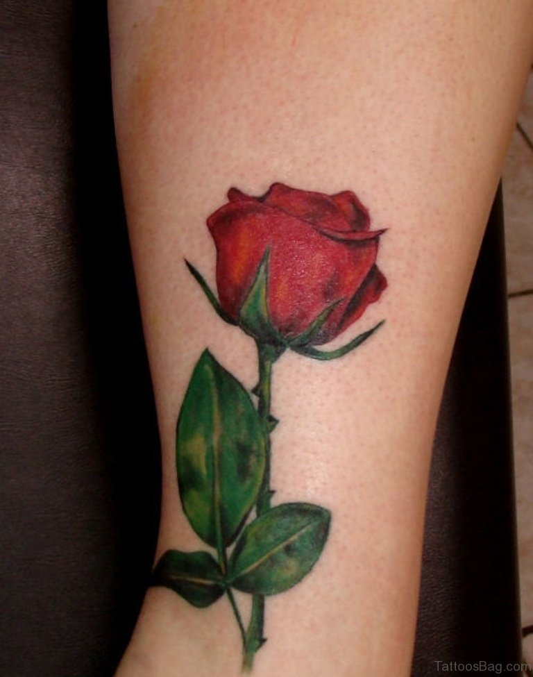 Red roses and green leaves leg tattoo for women.