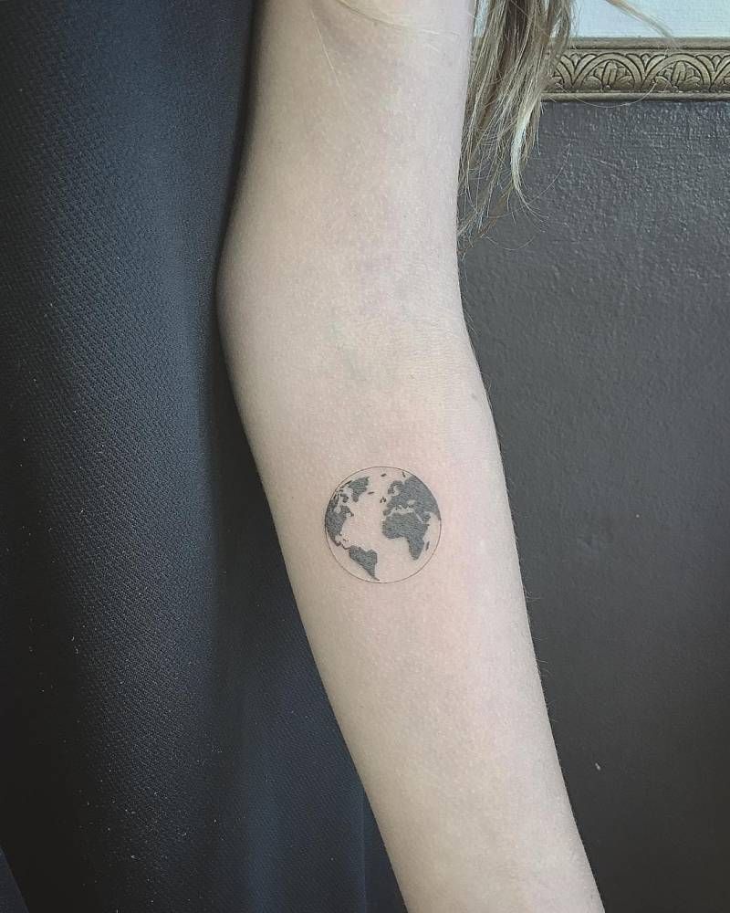 Small globe tattoo with map on inner arm