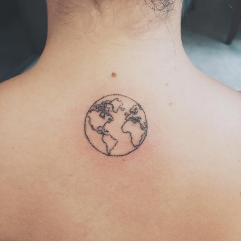 Small globe tattoo with map on mid upper shoulder