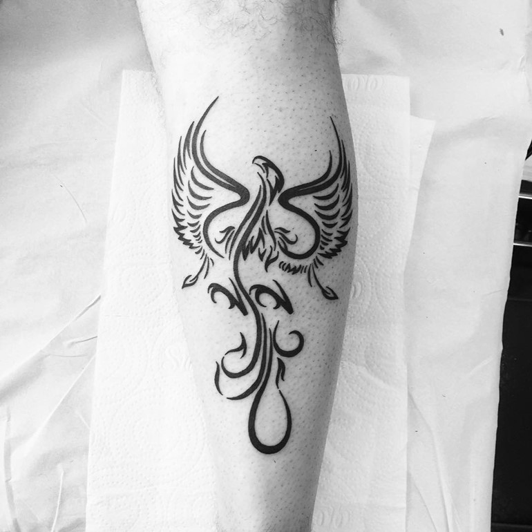 Tribal phoenix tattoo on outer forearm