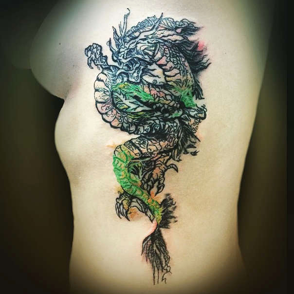 Green and black full dragon tattoo on left side of girl's body