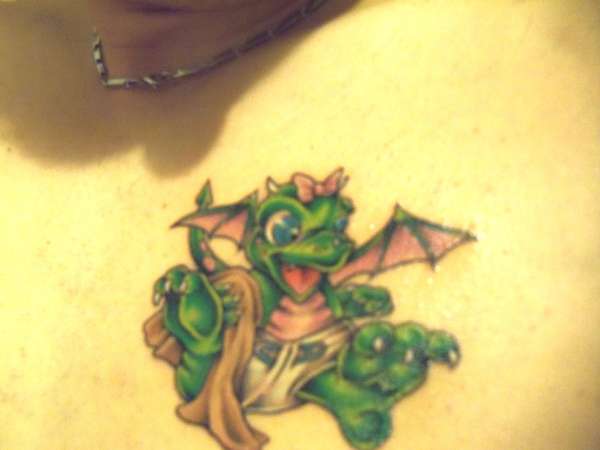 Green cute baby dragon tattoo on left side of chest
