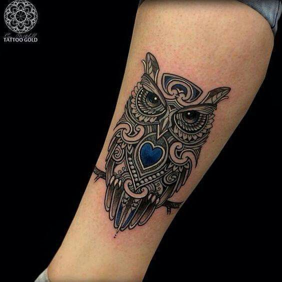 Attractive owl with blue heart tattoo on wrist