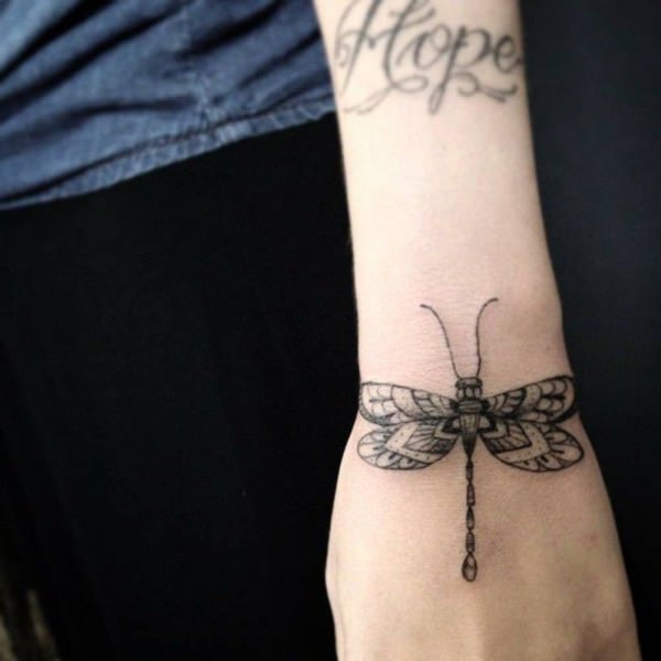 Black designed dragonfly tattoo design on wrist