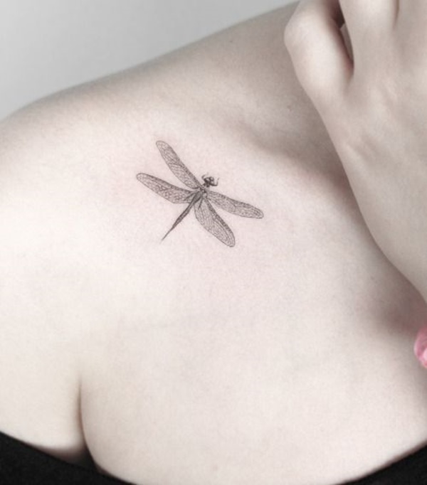Black dragonfly tattoo on front shoulder for women