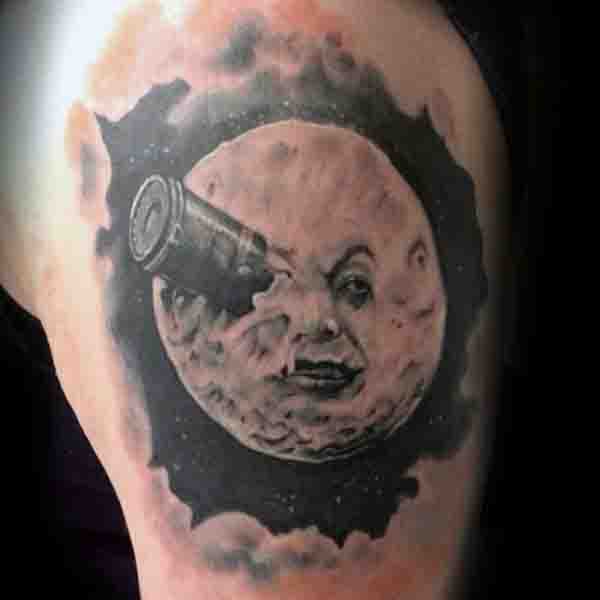 Black full moon with face tattoo on upper left arm for men