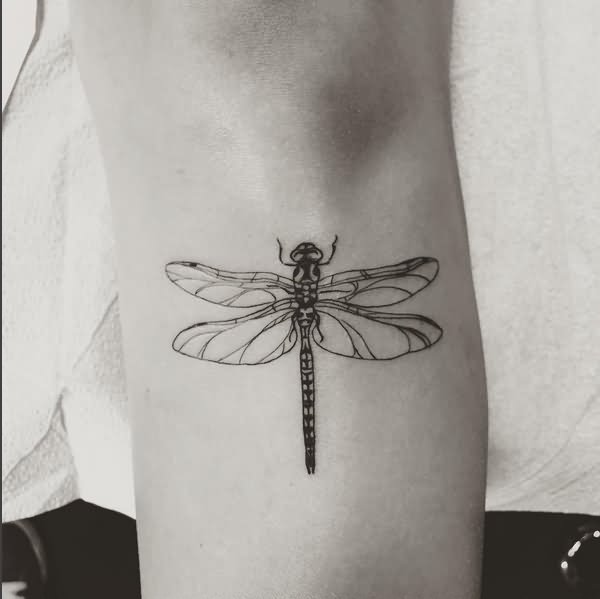 Black outline dragonfly wrist tattoo