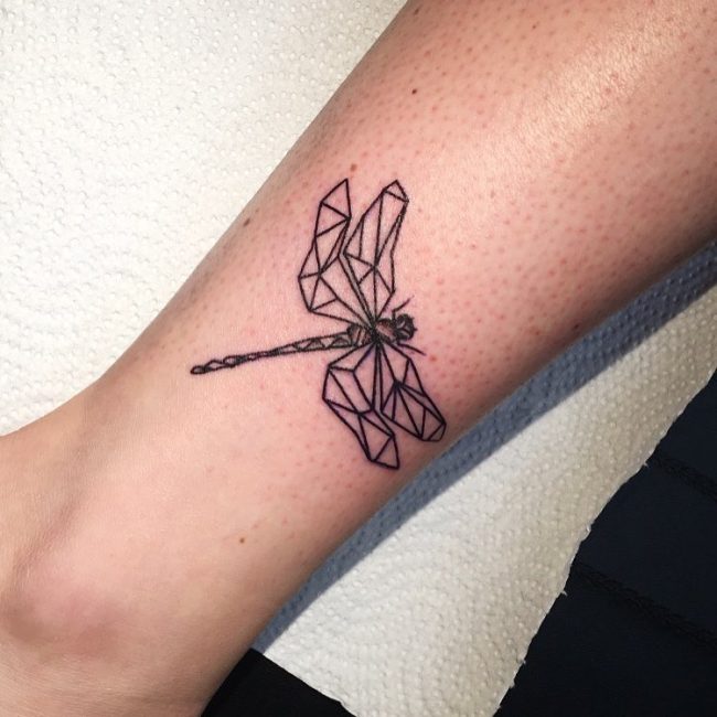 Black outline geometric dragonfly tattoo on girl leg