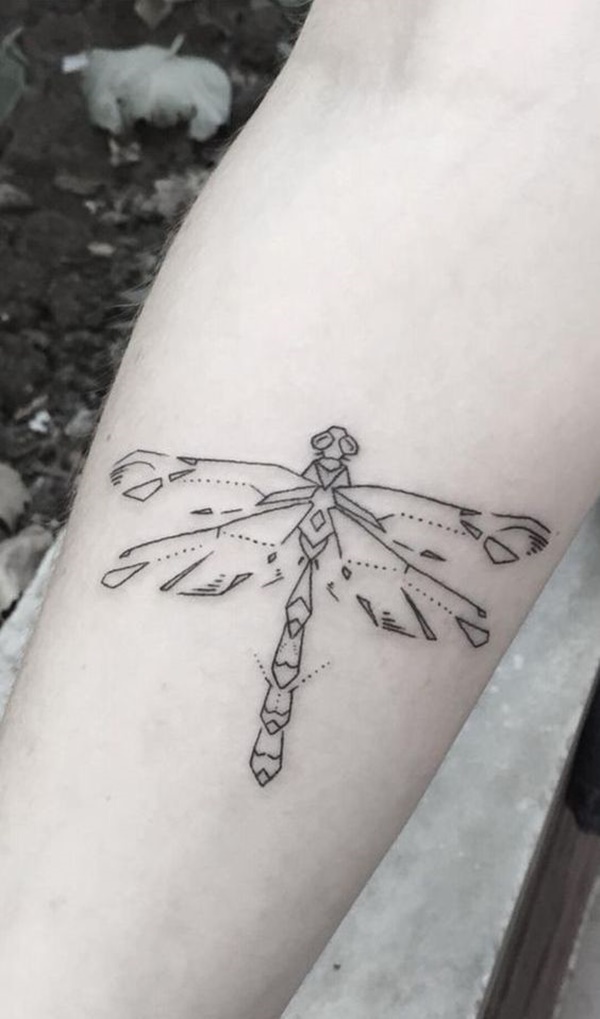 Black outlined dragonfly tattoo on inner arm