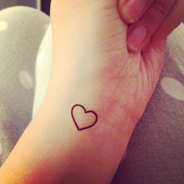 Black outlined small heart tattoo on left hand inner left wrist