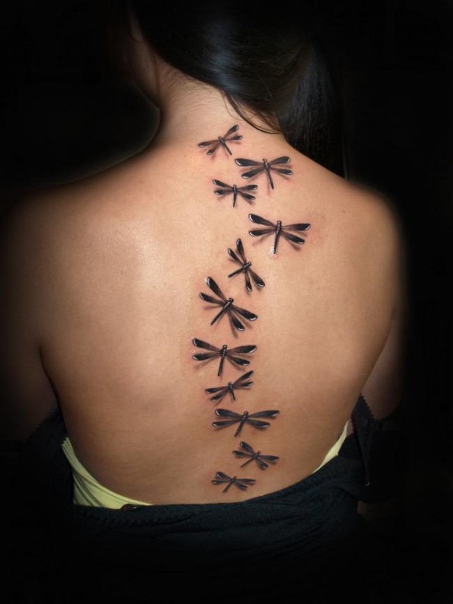 Black sequential dragonfly tattoo on full mid back