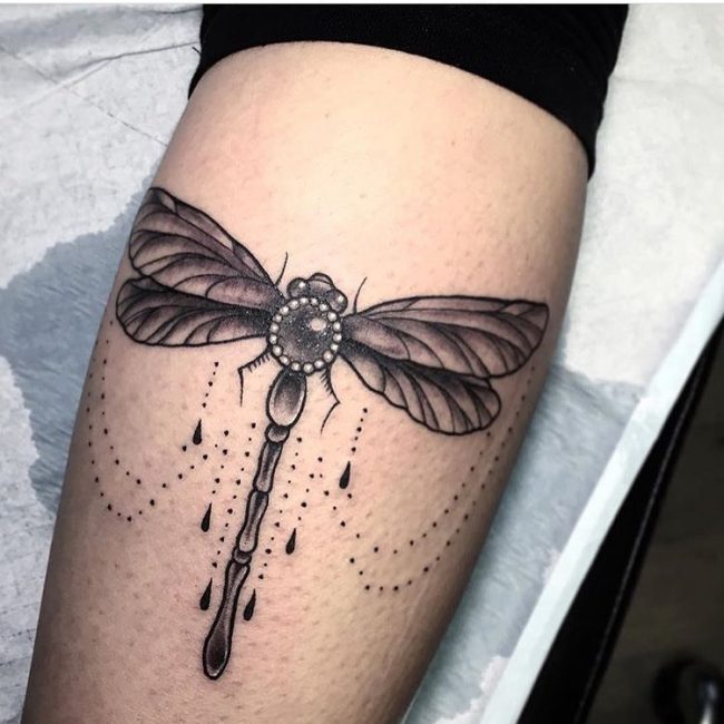 Black shaded celtic dragonfly tattoo on inner arm
