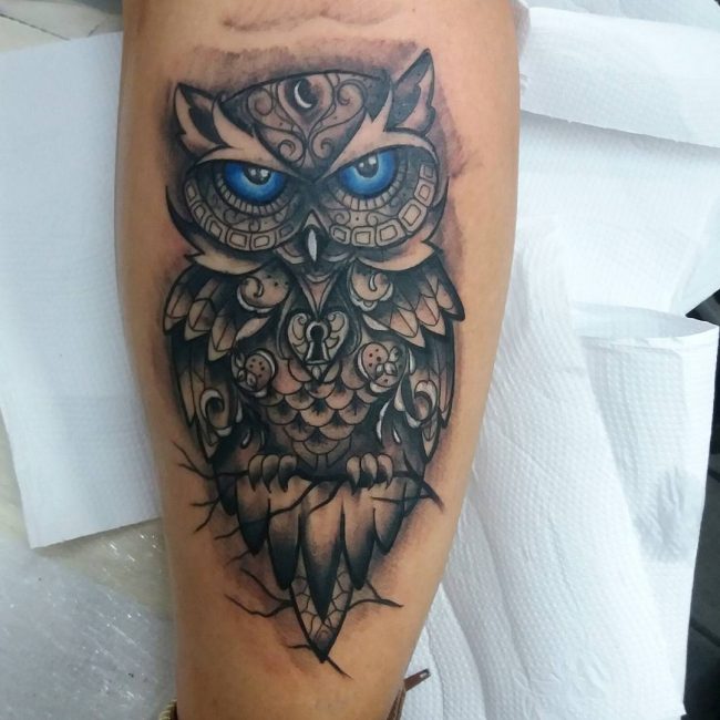 Blue eyed grey owl with lock tattoo design