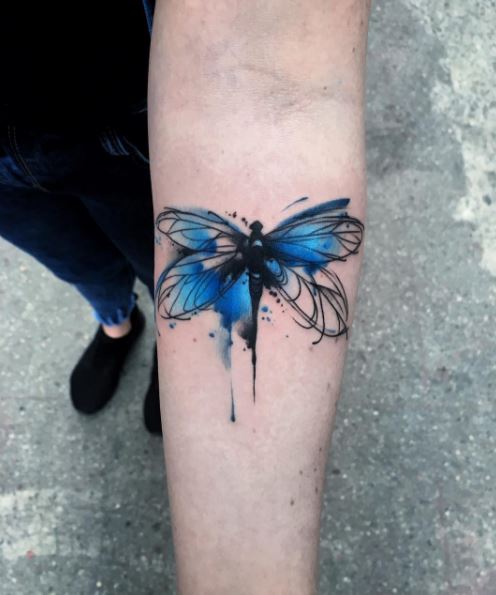 Blue watercolor dragonfly tattoo on inner arm for women