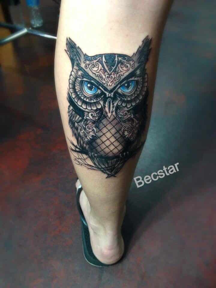 Blue eyed dark black ink owl tattoo on calf (leg)