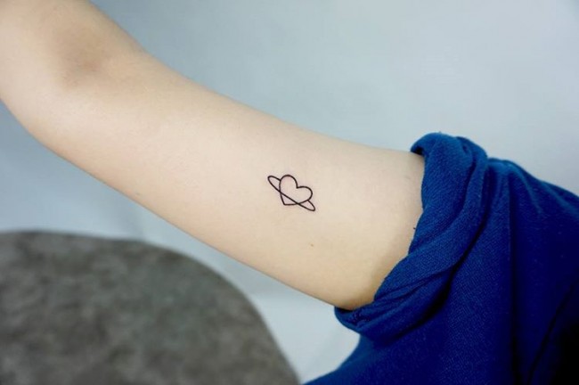 Cute small black outline heart in circle tattoo on bicep
