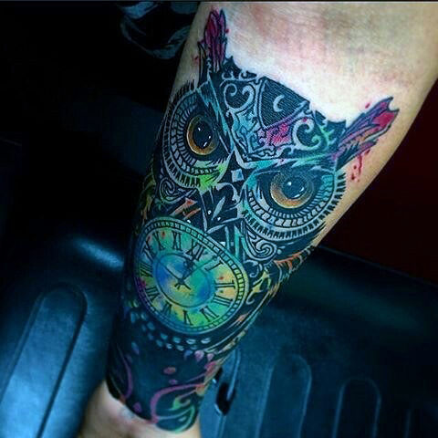 Dark colorful owl and clock tattoo on men forearm